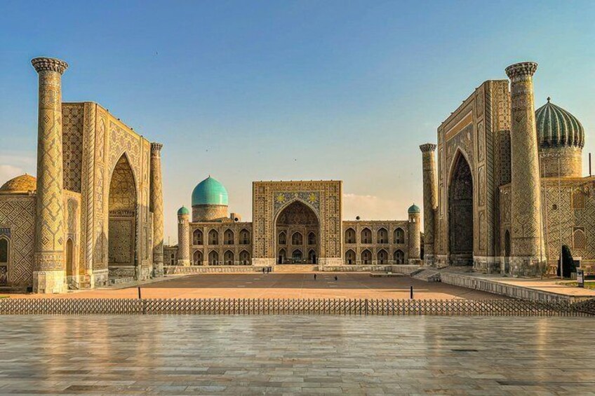A large, historic building with domes and arches, surrounded by a paved area. 1