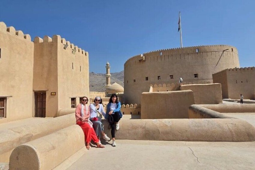 A historical fort with a flagpole, a minaret, and a clear sky. 1