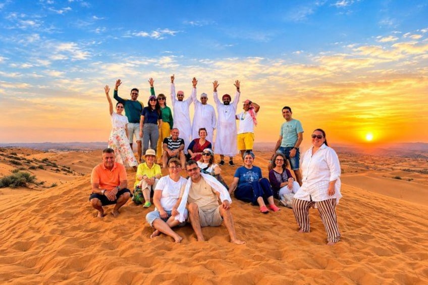 A group of people in a desert landscape at sunset. 1