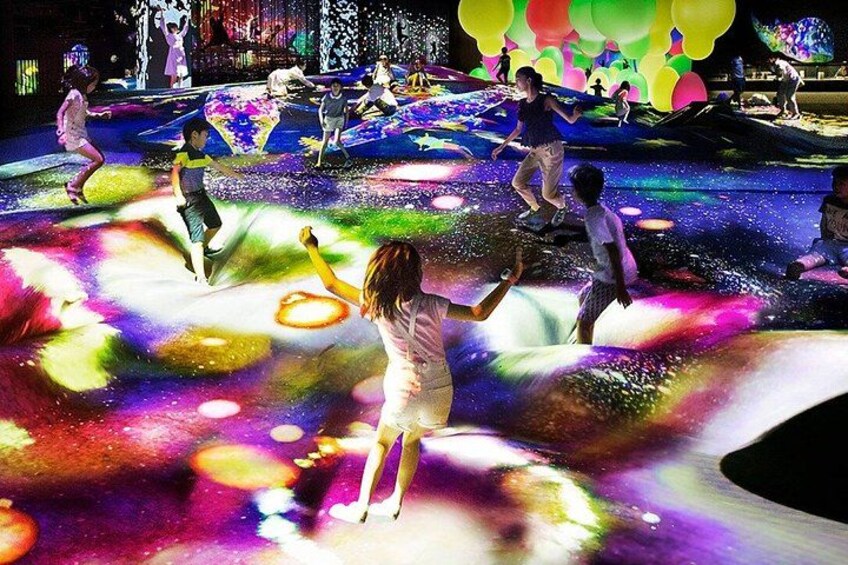 A water fountain with colorful lights and people enjoying the water feature. 1