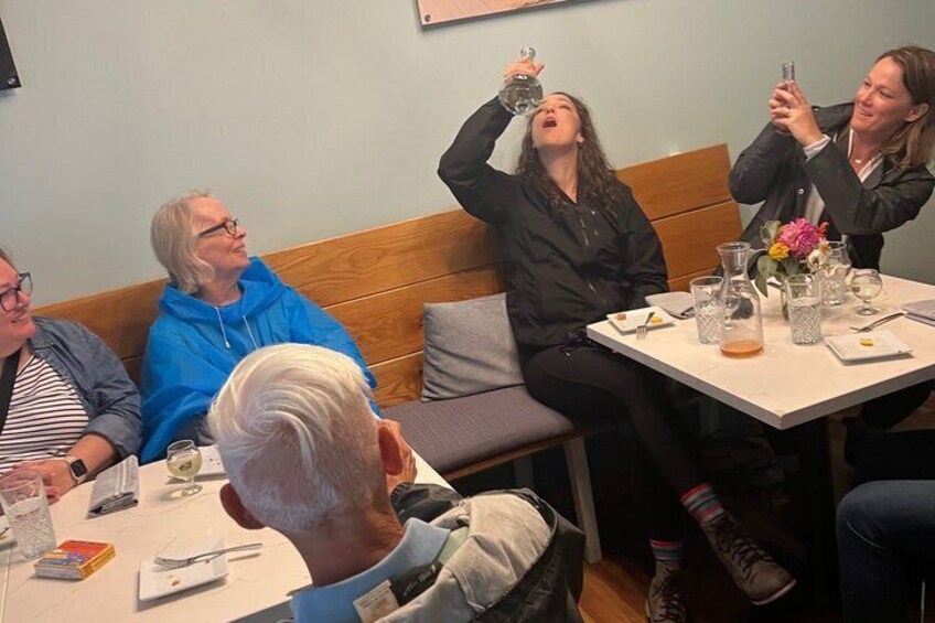 A group of people sitting at a table with drinks, engaged in conversation. 5
