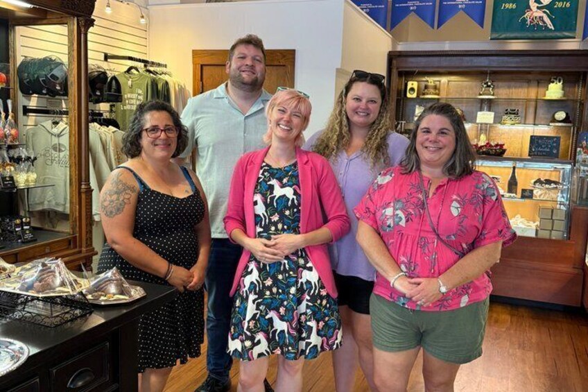 A group of people in a retail store with clothing items and accessories on display. 3