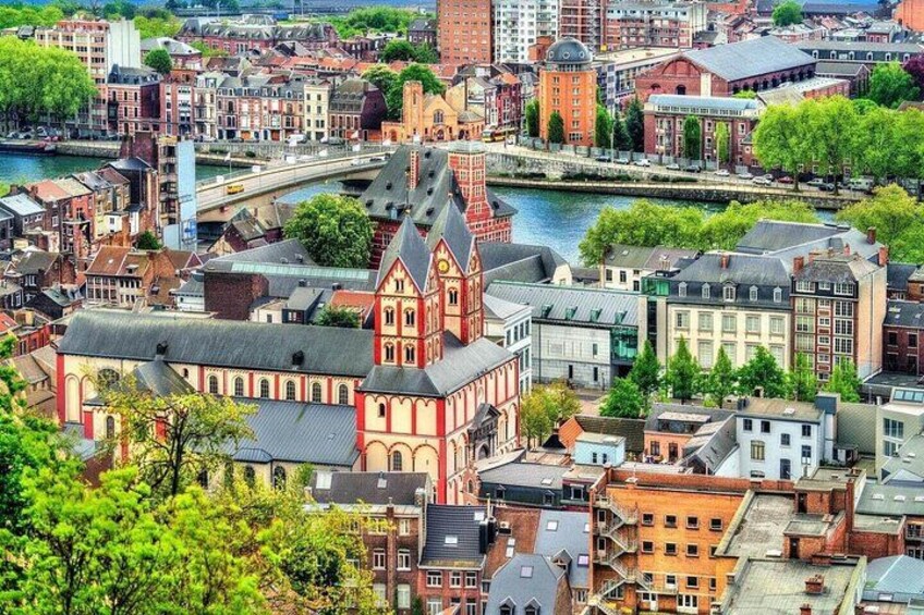 A cityscape with a prominent red church, a river, and various buildings. 1