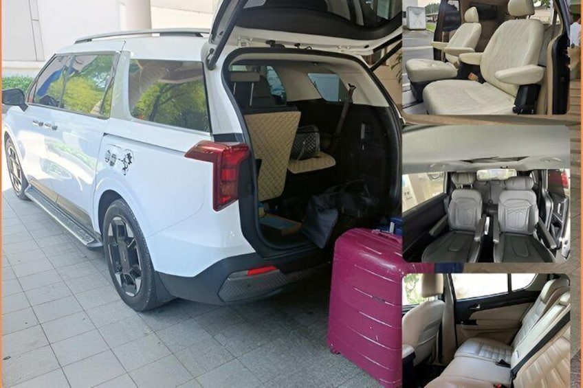 Un SUV blanco con el maletero abierto, mostrando una maleta rosa y una alfombrilla para el suelo color beige. 5