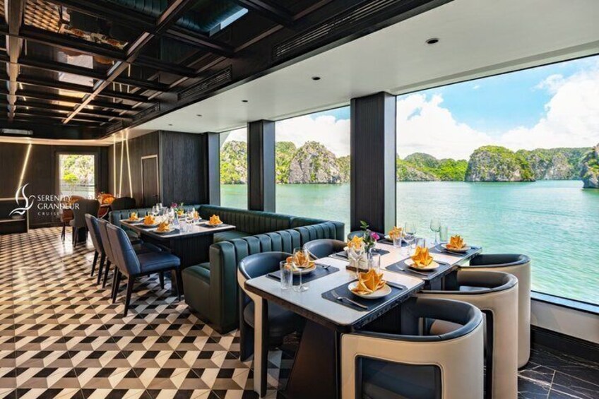 A restaurant with a checkered floor, tables set with yellow napkins, and a view of a lake. 1