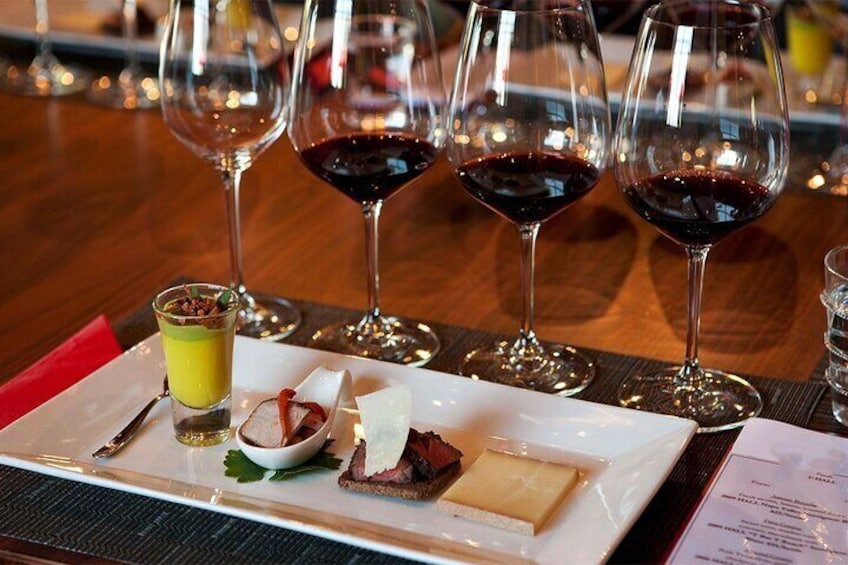 A dessert plate with various sweets and a glass of wine on a table. 2
