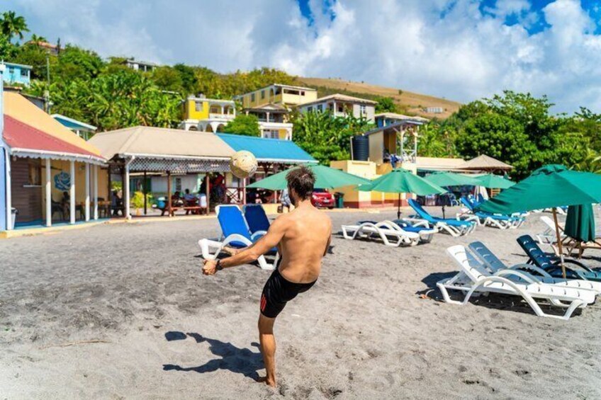 Una playa con tumbonas, sombrillas y una persona jugando con una pelota. 5