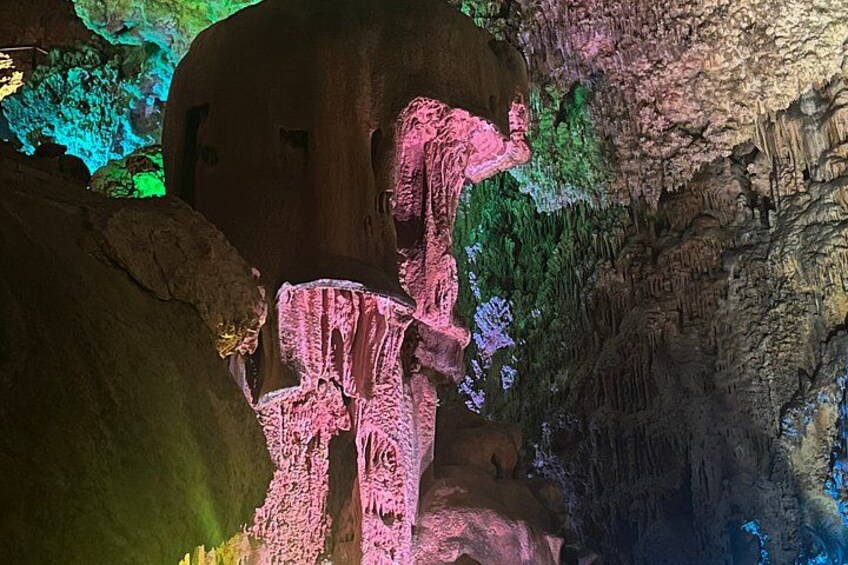A cave with colorful light projections on the walls and ceiling, creating a vibrant atmosphere. 1