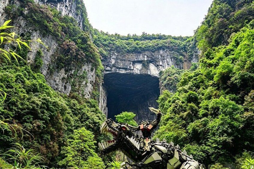 A canyon with lush greenery and a large, dark opening. 2