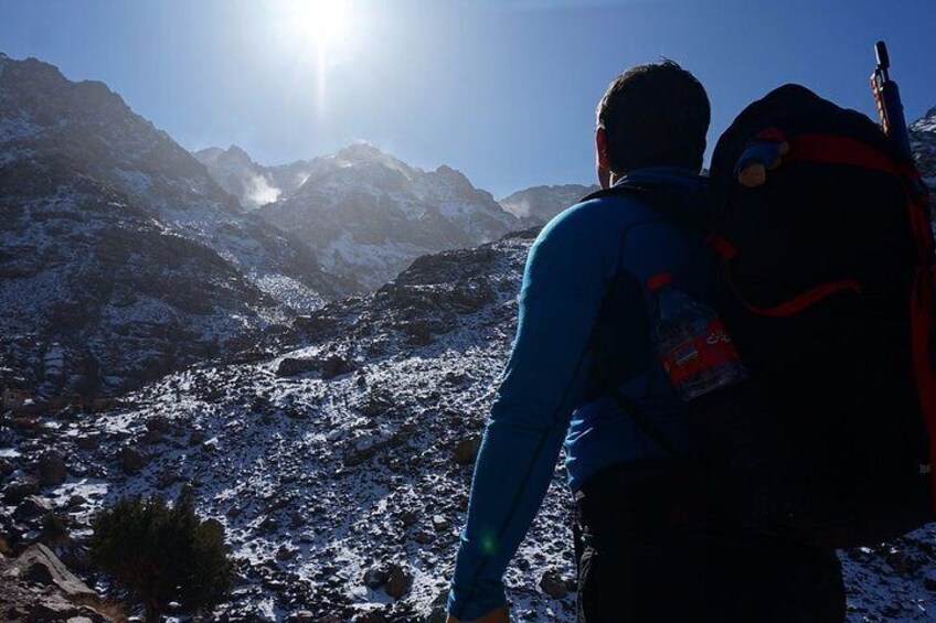 A person hiking in a snowy mountainous area with a backpack. 3