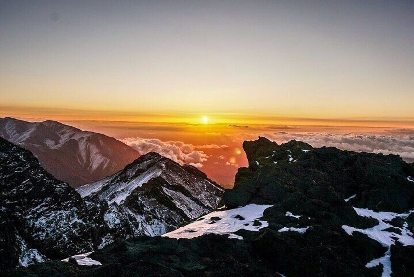 A mountain range with a sunset over the clouds. 2