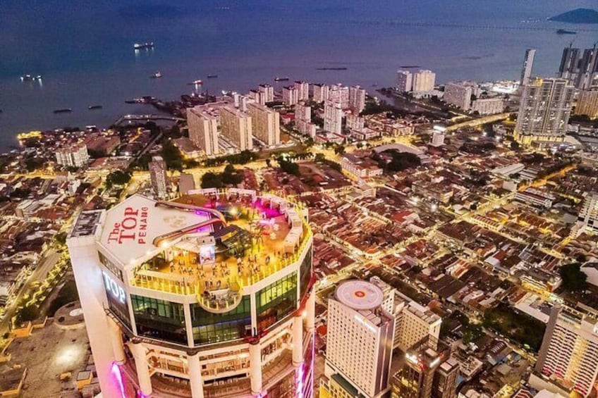 A cityscape with a prominent building featuring a circular plaza and a large sign. 3
