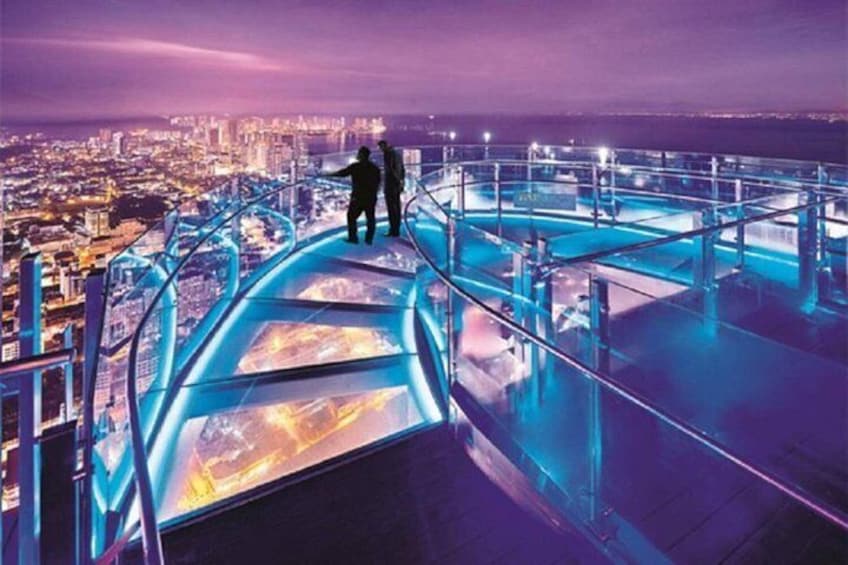 A nighttime cityscape with a glass bridge and two people standing on it. 1