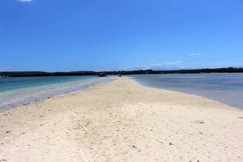 A beach with clear water and a distant shoreline. 2