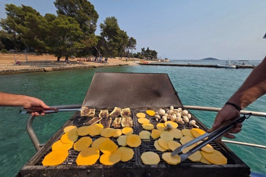 A grill with yellow and white items being cooked, a body of water, and trees in the background. 5