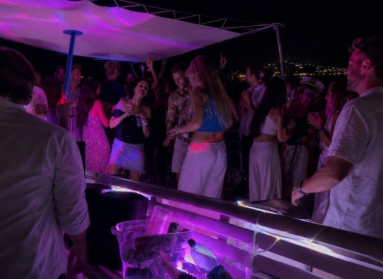 A group of people dancing under a canopy at night. 4