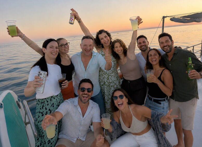 A group of people on a boat with drinks, ocean in the background. 3