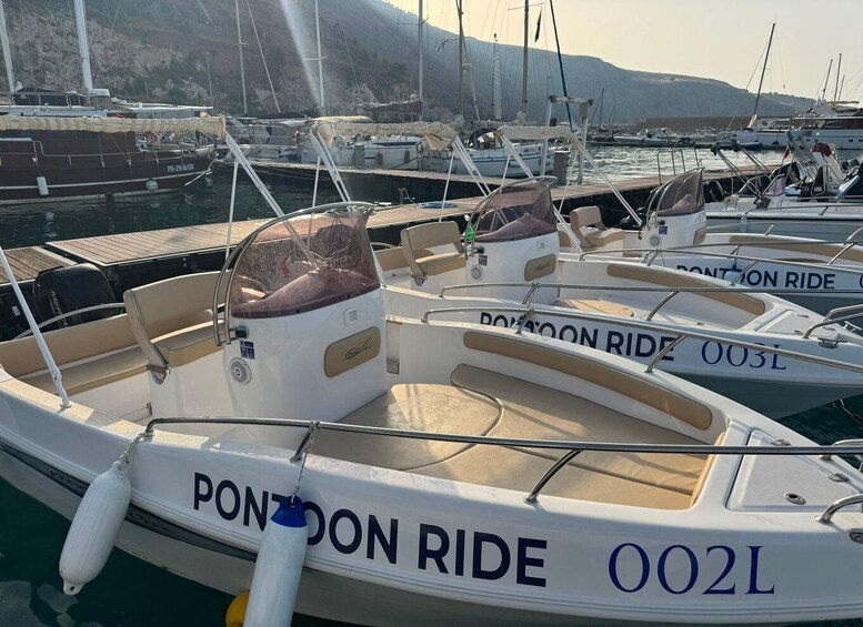 A marina with several boats docked, including a prominent white boat named 'PONTON RIDE' with the number '002L'. 5