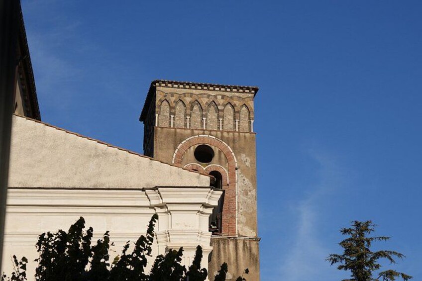 A building with a clock tower, arched windows, and a clear blue sky. 5