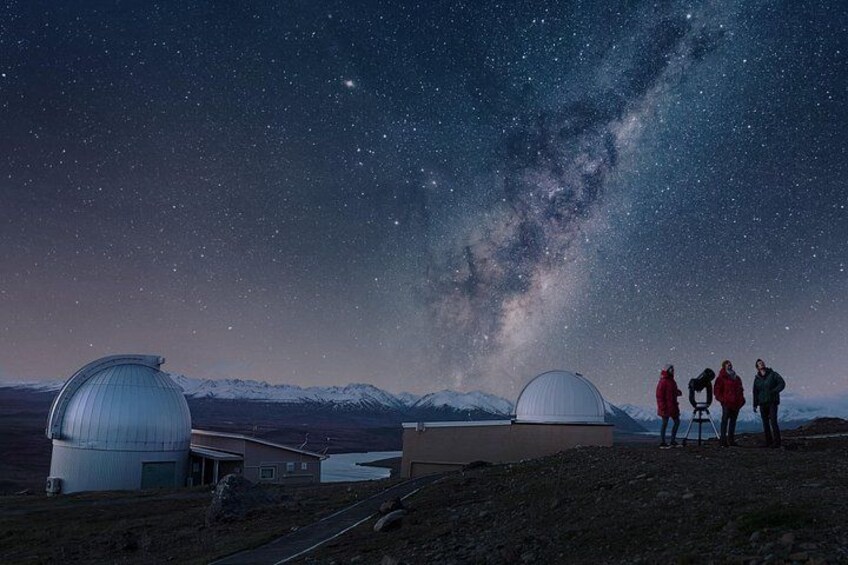 A starry night sky with the Milky Way visible, a telescope dome, and a mountainous landscape. 2