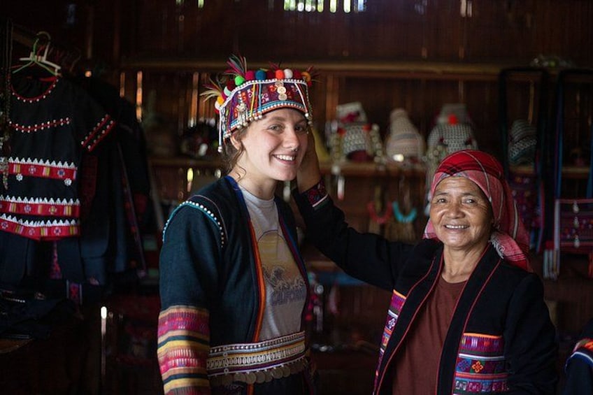 A person wearing a traditional headdress and a jacket with colorful patterns. 1