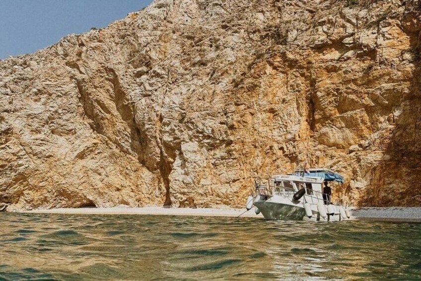 A boat anchored near a rocky cliff. 4