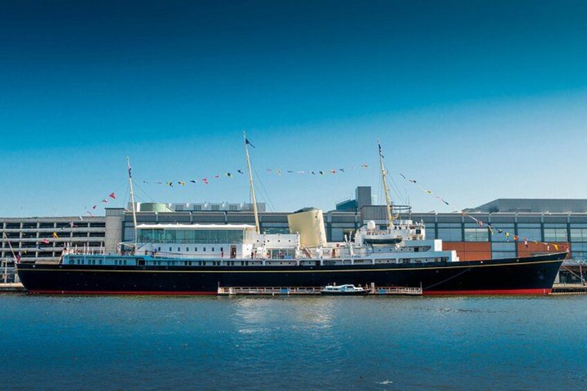 A large ship docked at a port with buildings in the background. 4