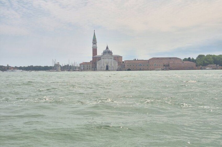 A body of water with a historic building and a tall tower in the background. 3