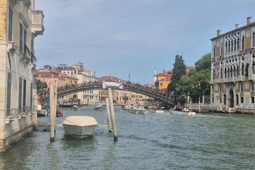 A canal with boats, a bridge, and historic buildings. 1