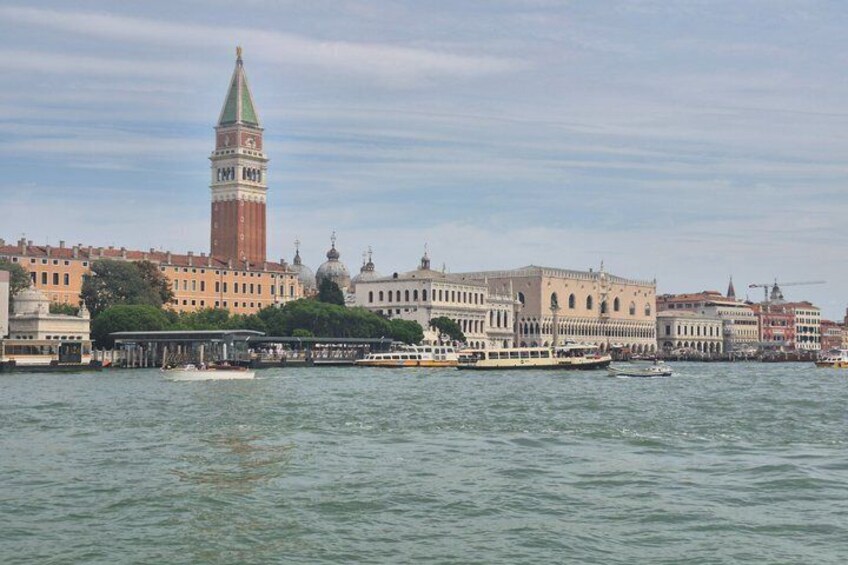 A river with boats, a prominent tower, and historic buildings along the waterfront. 2