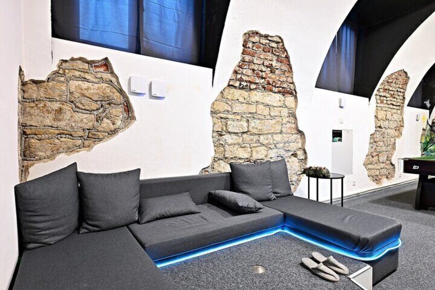 A modern living room with a sectional sofa, a coffee table, and a wall with exposed brick. 4