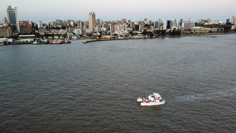 A river with a boat in the foreground and a cityscape in the background. 3