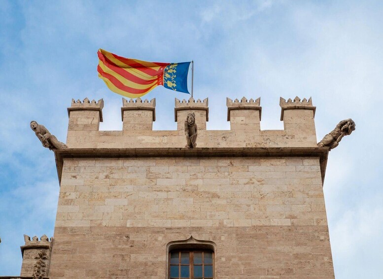 A stone castle with battlements and a flag with red and yellow stripes and a blue emblem. 4