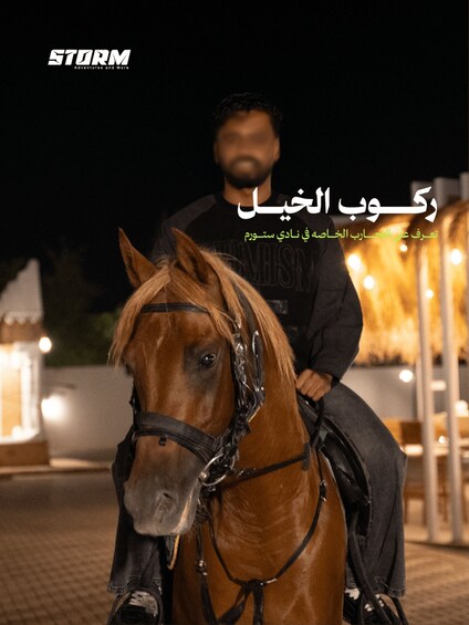 A person riding a horse at night with lights in the background. 1