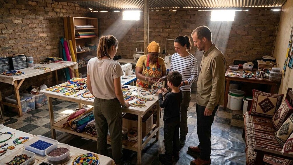 A group of people in a workshop with tables displaying colorful beaded jewelry. 2