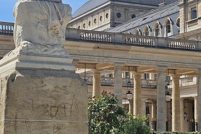 A classical building with columns, a statue, and a balcony. 4