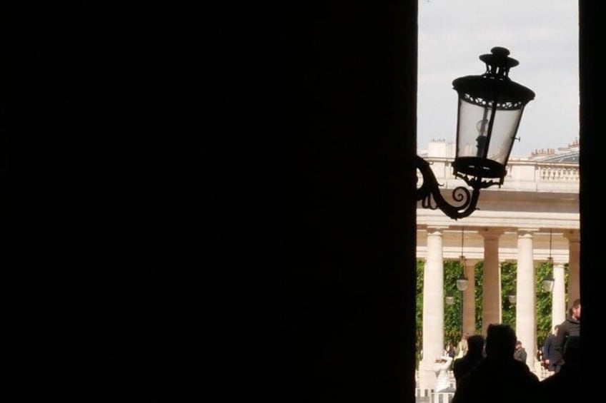 A street lamp, a building with columns, and a crowd of people. 3