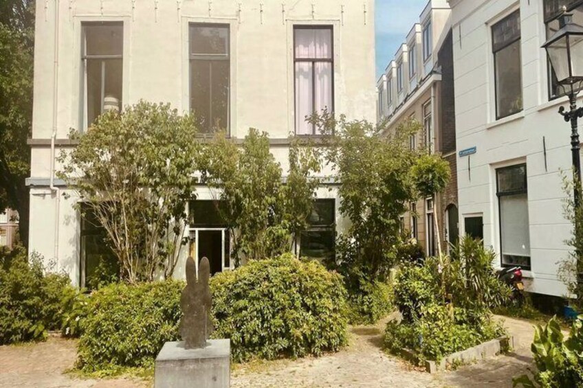 A courtyard with a statue, surrounded by buildings and greenery. 5