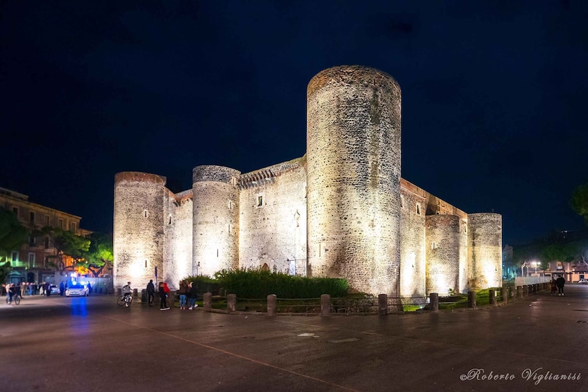 A historic castle with multiple towers and walls, illuminated at night. 3