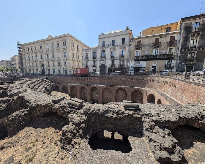 Ancient ruins with arches, a modern building, and a clear sky. 2