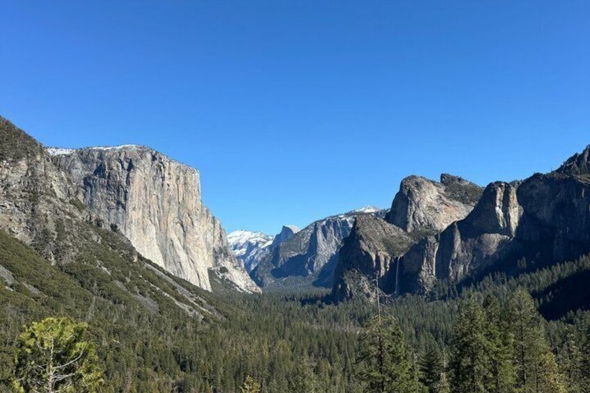 A mountainous landscape with prominent rock formations and dense forest. 1