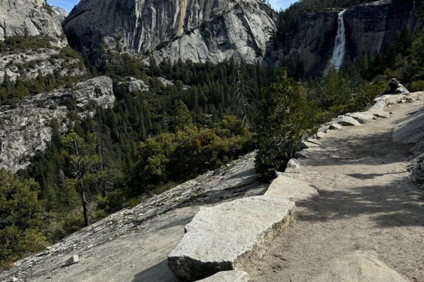 A rocky trail with a waterfall in the background. 3