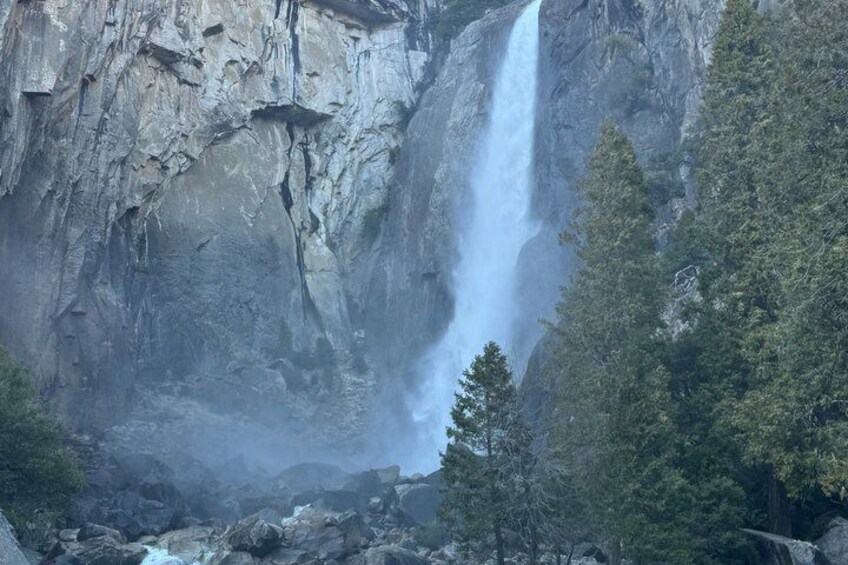 A waterfall cascading down a rocky cliff surrounded by trees. 5