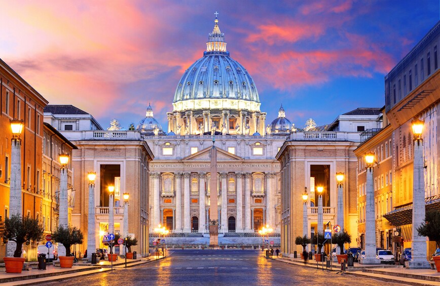 A grand building with a large dome and columns, surrounded by trees and street lamps. 5