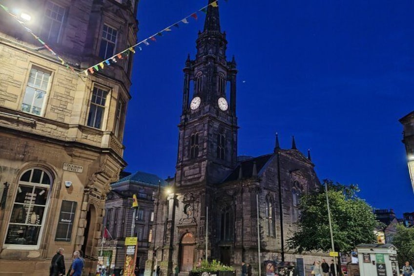 A historic building with a clock tower, street lamps, and a sign indicating a market area. 4