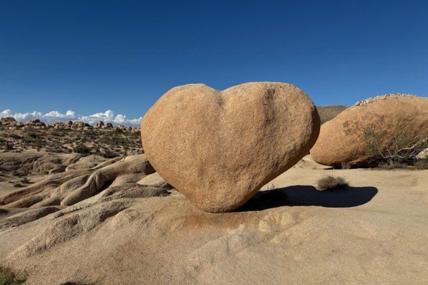 A heart-shaped rock formation in a desert landscape. 3