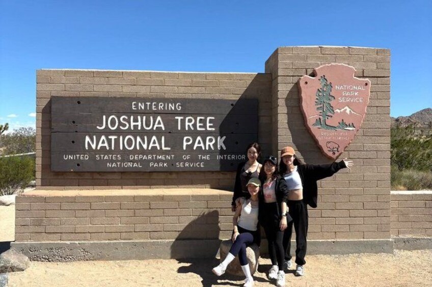 A sign for Joshua Tree National Park with a logo of the National Park Service. 1