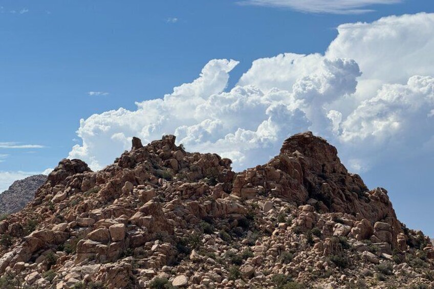 A rocky mountain landscape with sparse vegetation under a clear sky. 3