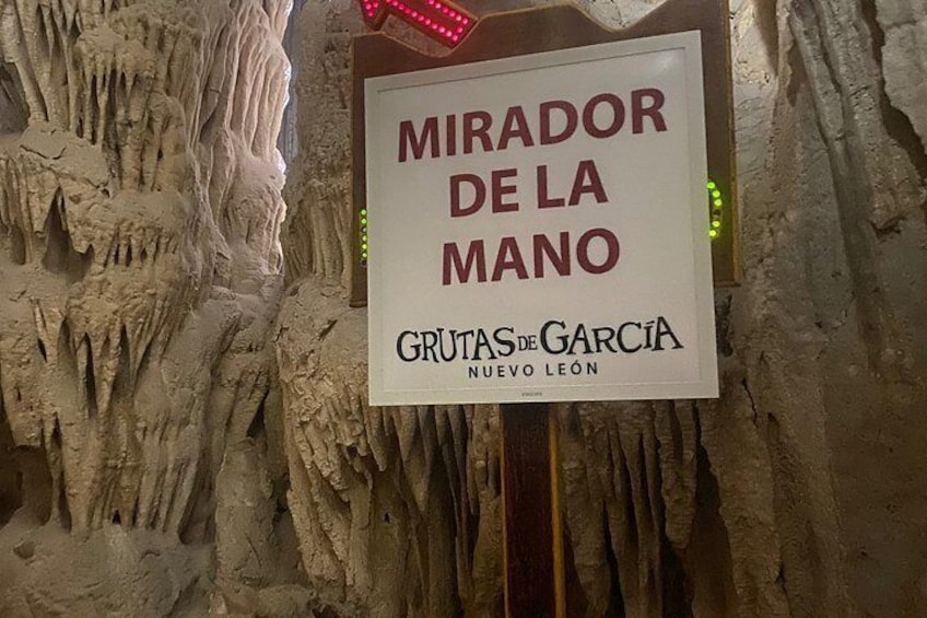 A cave wall with stalactites and a sign reading 'Mirador de la Mano' and 'Grutas de Garcia Nuevo León'. 1