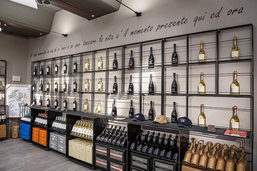 A wine store with shelves of wine bottles and a wall with a quote. 3